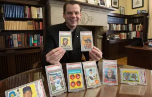 Father Ubel with baseball cards. Dave Hrbacek / The Catholic Spirit. Used with permission.